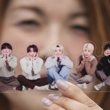 Une fan de groupe de K-pop BTS pose avec une photo de la formation. KEYSTONE/AP/Lee Jin-man